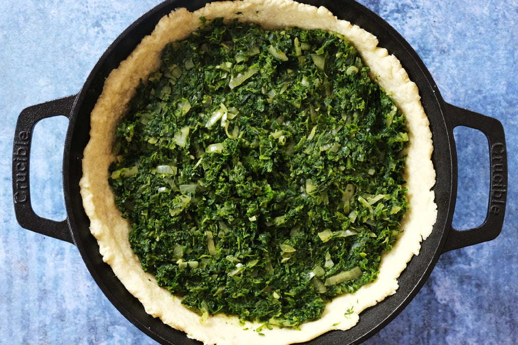 spinach in pie crust cooked in a cast iron skillet