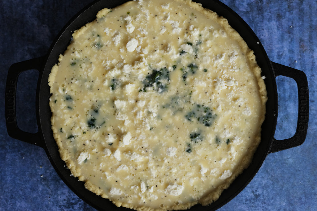 preparing spinach pie in a cast iron skillet frying pan