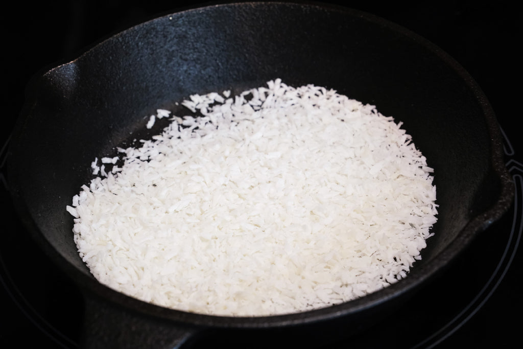 roasting coconut flakes in a cast iron skillet