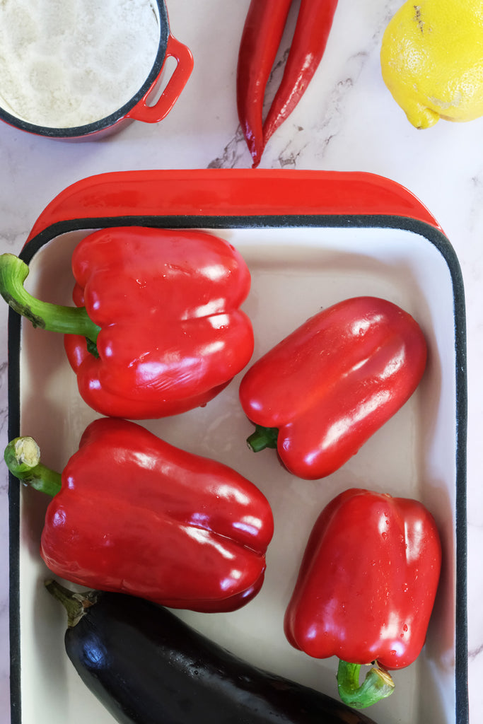 eggplant and bell peppers in an enameled cast iron roasting pan