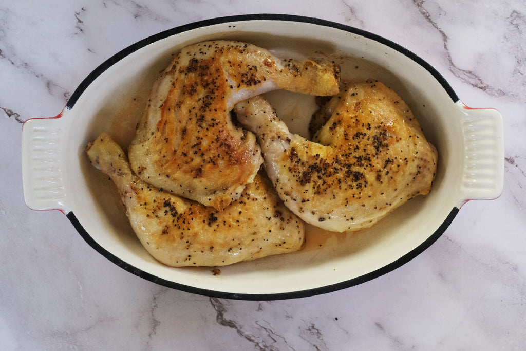 chicken legs in an enameled cast iron roasting pan