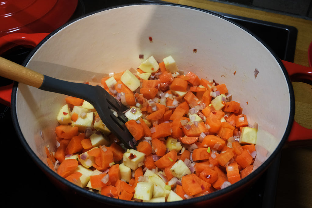 sizzling vegetables in an enameled cast iron dutch oven