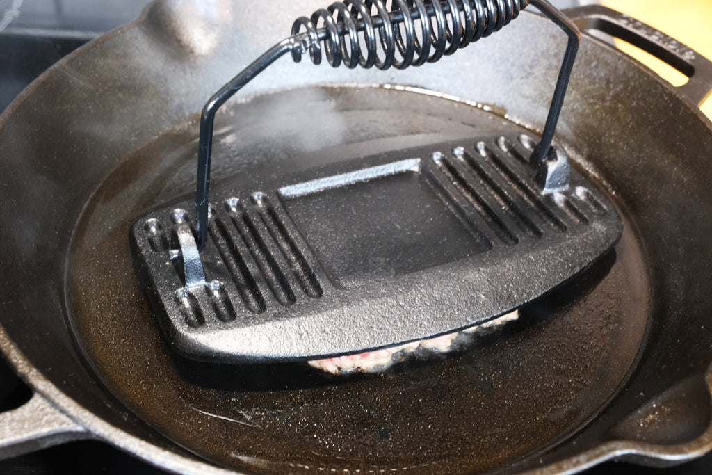 spreading the ground beef with a meat press