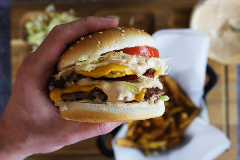 holding smashed burger in hand