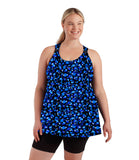 Front view of plus size woman wearing AquaSport plus size tankini top and fitted swim short.  Tankini features our Ocean Blues print, multi blue bubbles with two solid black bands around each shoulder strap. Long fitted swim shorts are solid black.