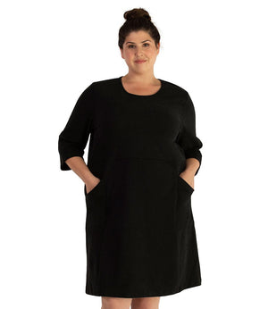 Plus size woman wearing black JunoActive Legacy Cotton 3/4 sleeve dress with pockets.