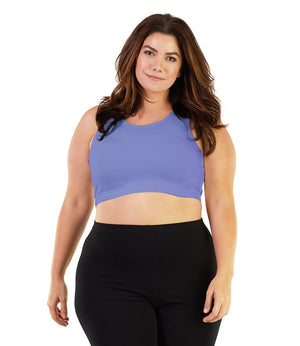 Plus size woman wearing black leggings and a purple JunoActive scoop neck bra top.