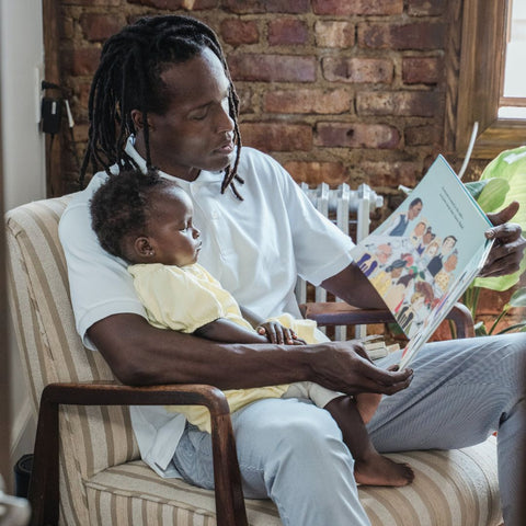 Father reading print book to child