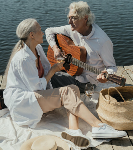 Elderly man serenading his love at a picnic