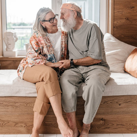 Elderly Couple Sharing Intimate Time While Sitting on Bed
