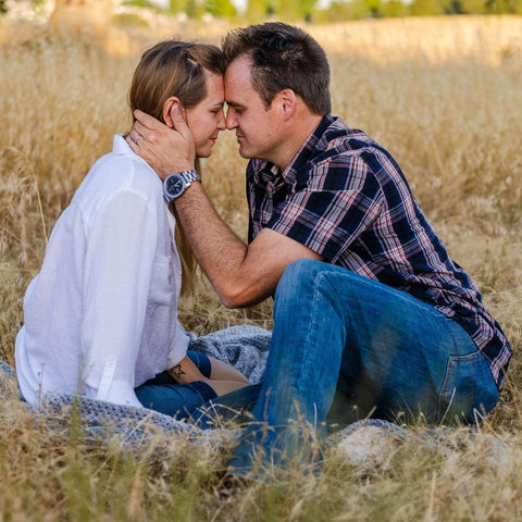 Couple Sitting in field preparing to kiss