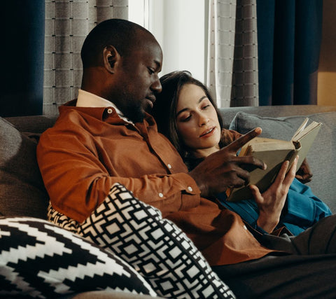 Interracial couple sharing time together reading a book