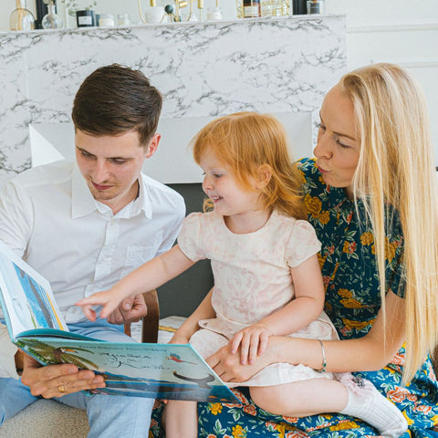 Parents reading to daughter