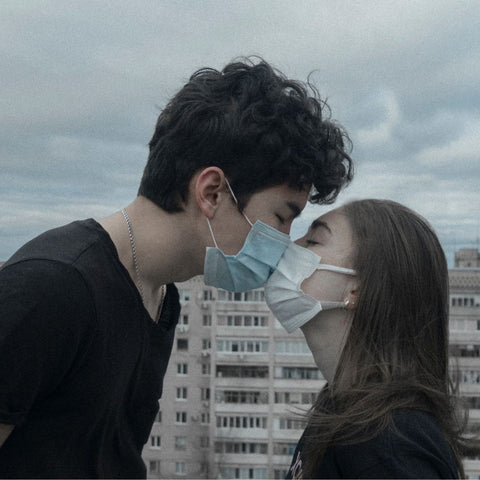 Couple kissing while wearing mask to prevent covid spread