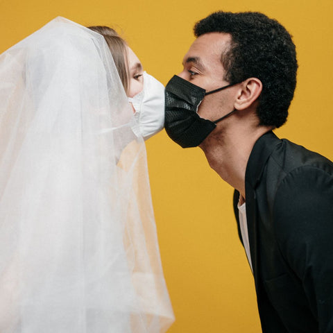 Married couple wearing mask for first kiss
