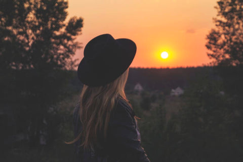 woman wearing hat in sunset