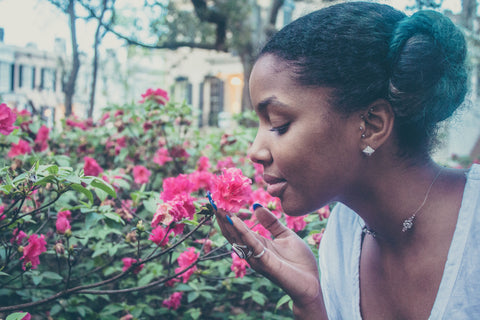 girl sniffing plant blossoms