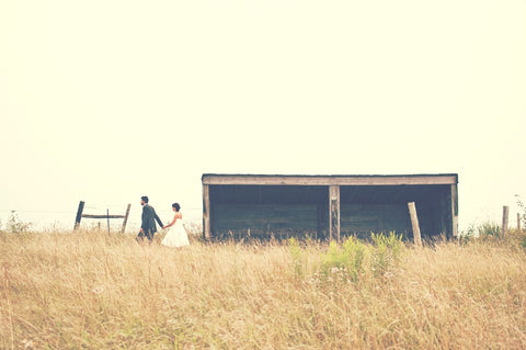 married couple walking in field