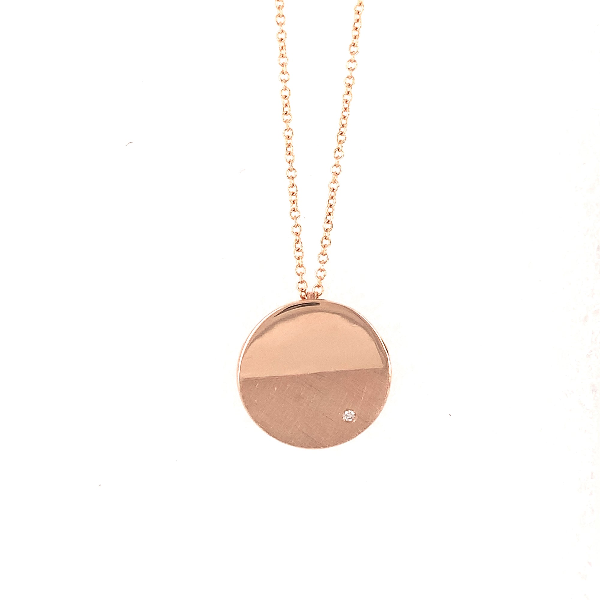 14k rose gold small circle pendant with complimenting satin and shiny finish and a single white diamond on a 1.0mm rolo link chain