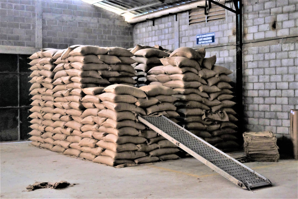 A neat stack of bags of coffee in a warehouse