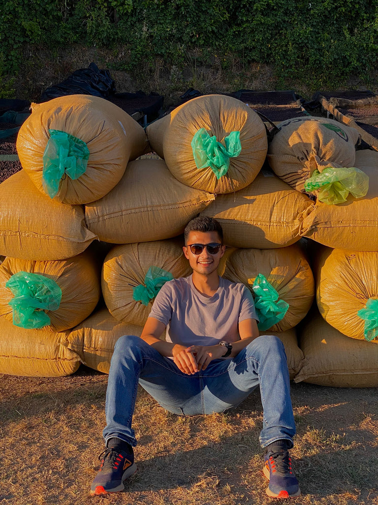 Diego Baraona sitting in front of bags of coffee