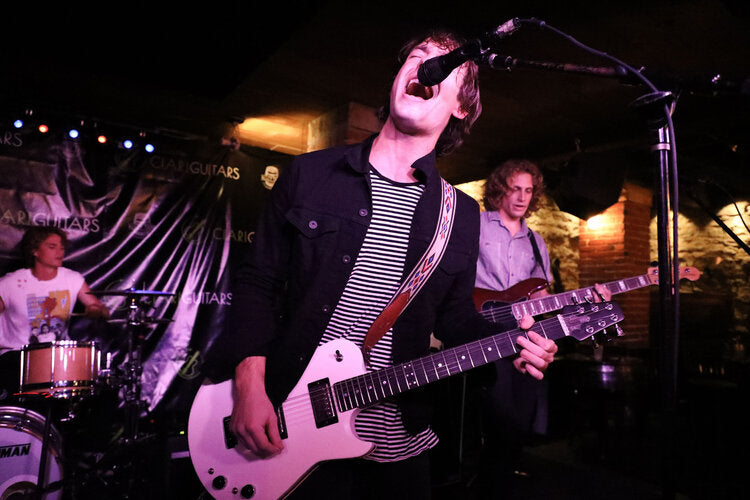 The Revelries play the Ascender guitar on stage