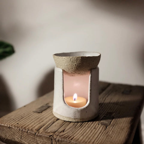 Oil burner with lit candle melting a wax melt
