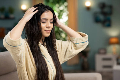 Woman massaging her scalp with damp hair