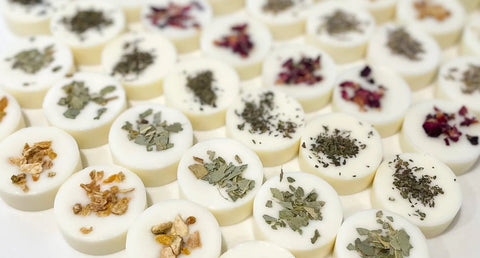 Rows of circular wax melts with various botanicals sprinkled on the top