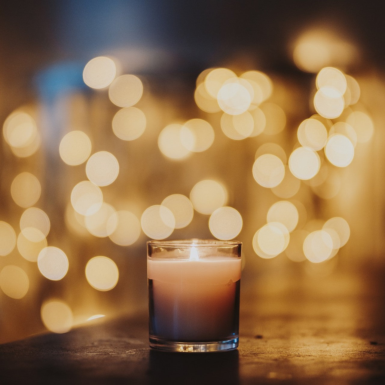 Burner candle at night with lights in the background