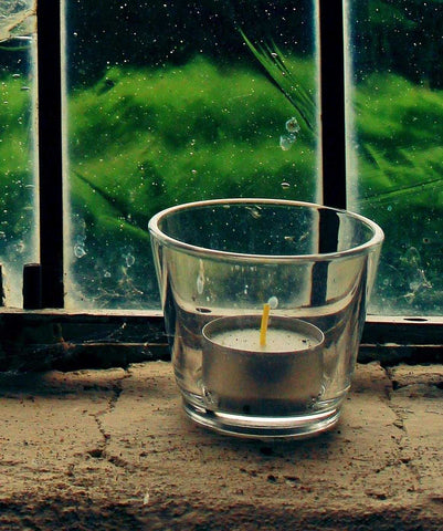 Small candle placed on a window sill