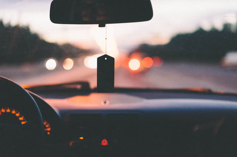 View through windshield with an air freshener at dusk