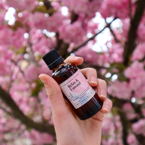 Relax & Unwind 50ml bottle with cherry blossom tree background