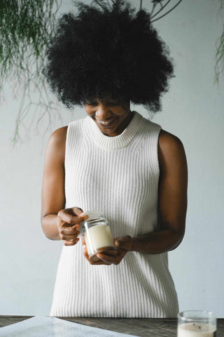 Woman applying a clp label onto the bottom of a candle