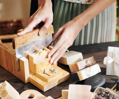 Woman cutting soap bars with a metal mould cutter