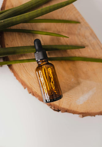 Amber glass essential oil bottle placed on a wooden board