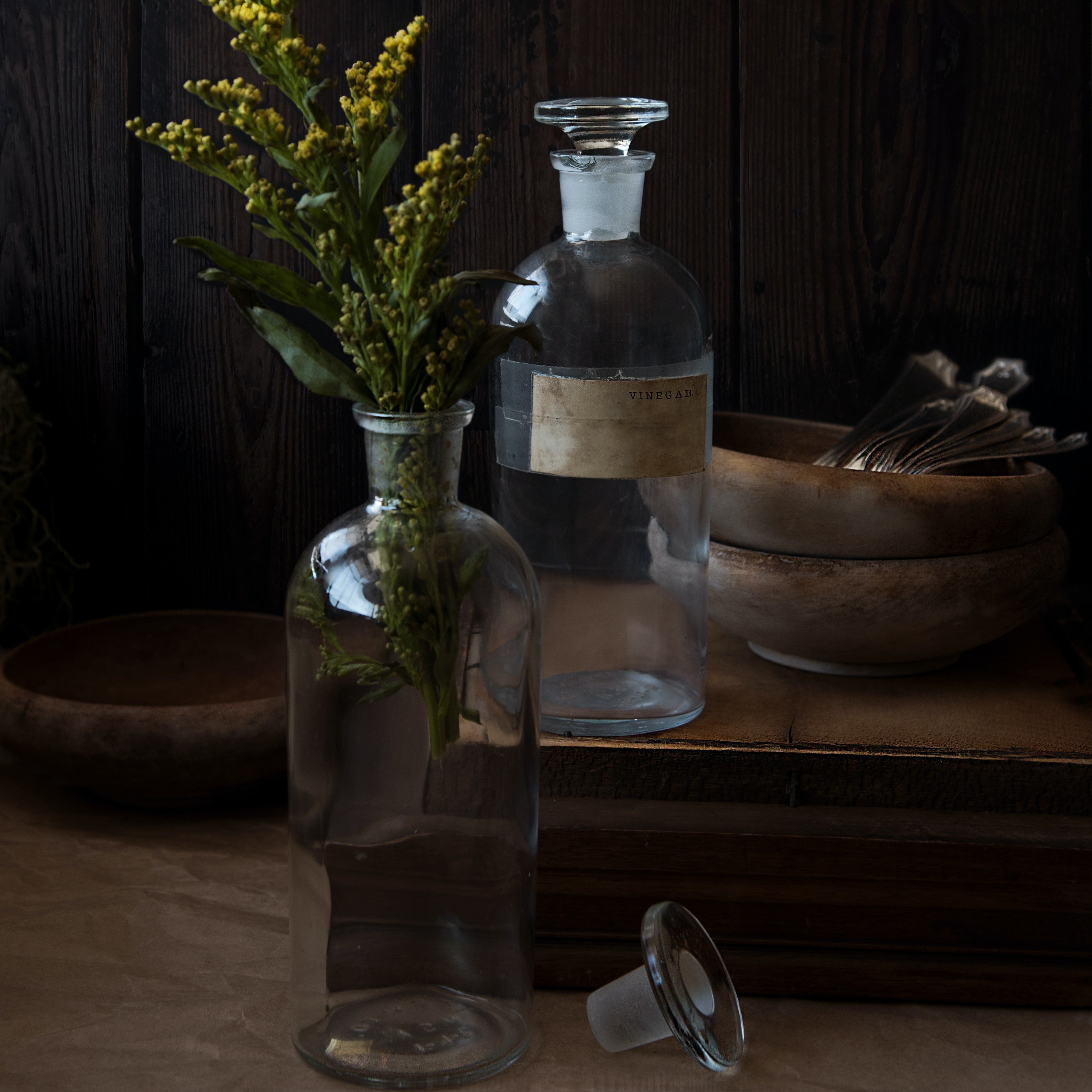 Two glass vials on wooden table.