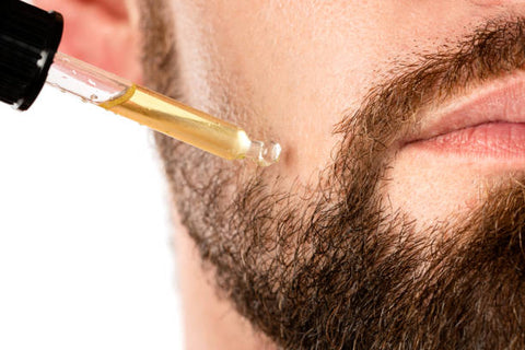 A man applying oil to his beard