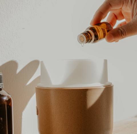 Dropping essential oils into a diffuser