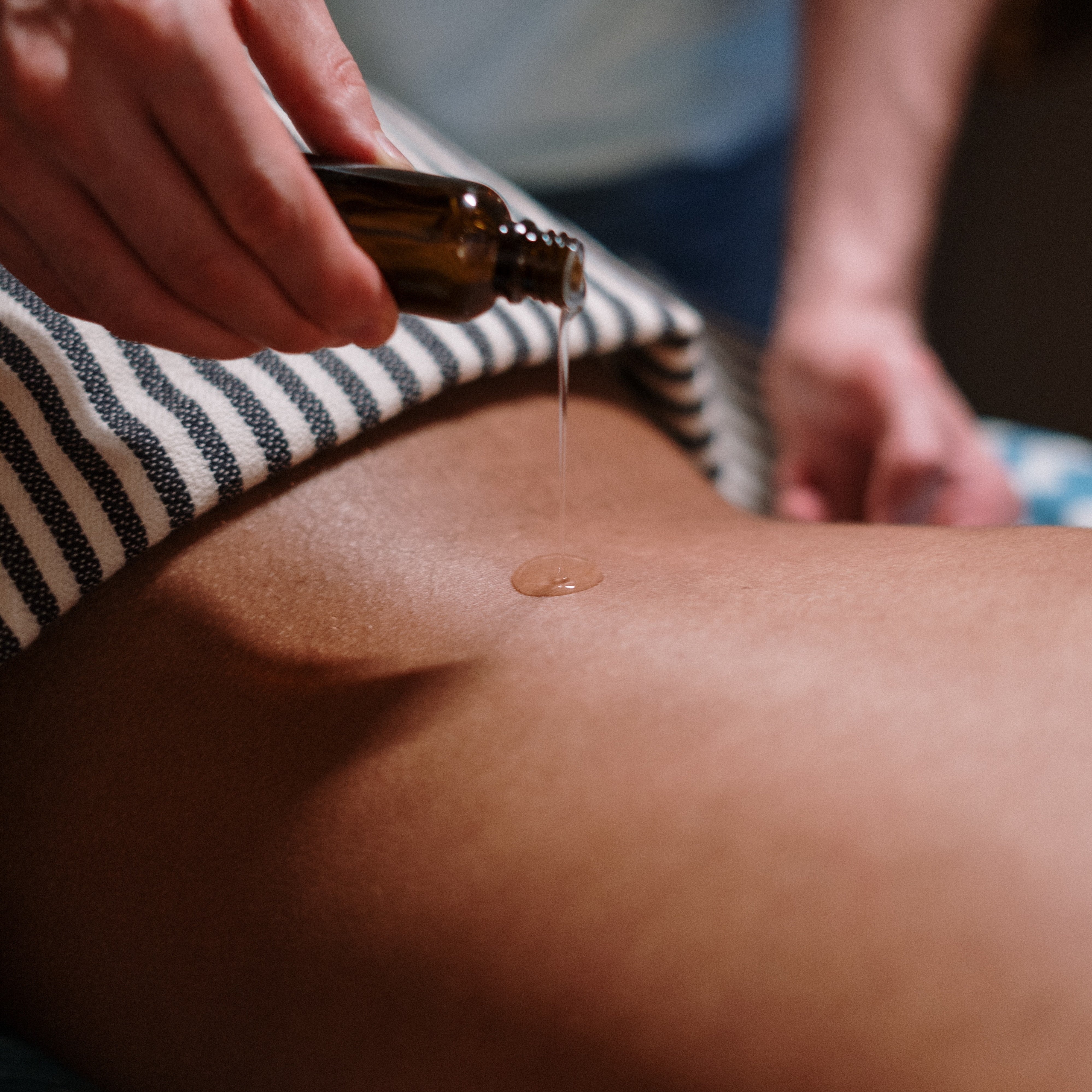 Massage oil being applied to back.