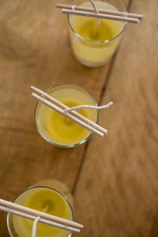 Three candles with yellow wax and wick positioners in place