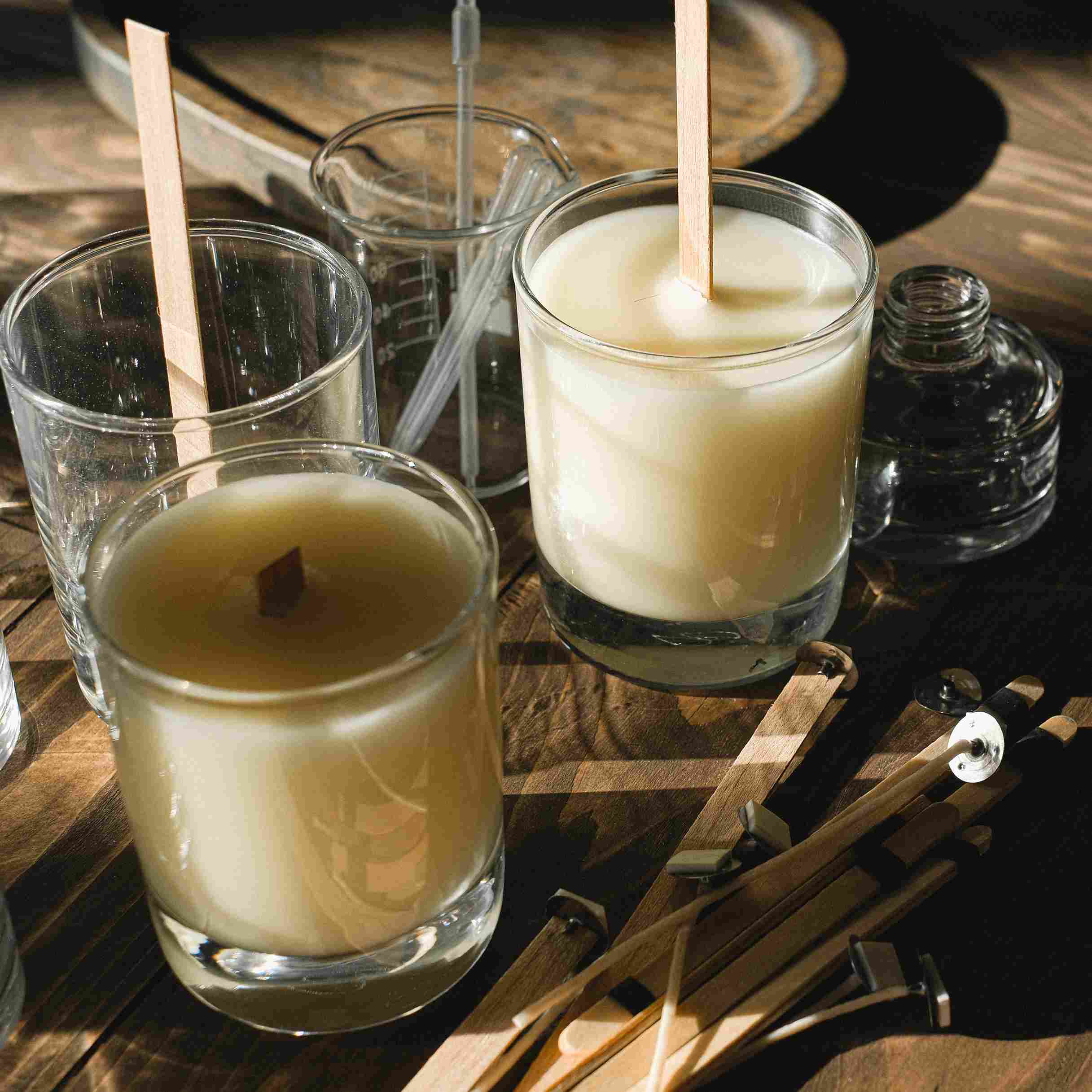 Candles being made surrounded by wooden wicks.