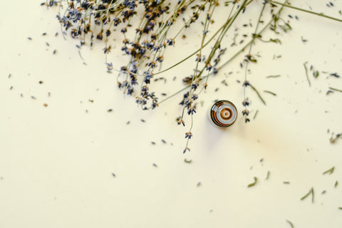 Amber glass bottle with dried lavender sprinkled around it