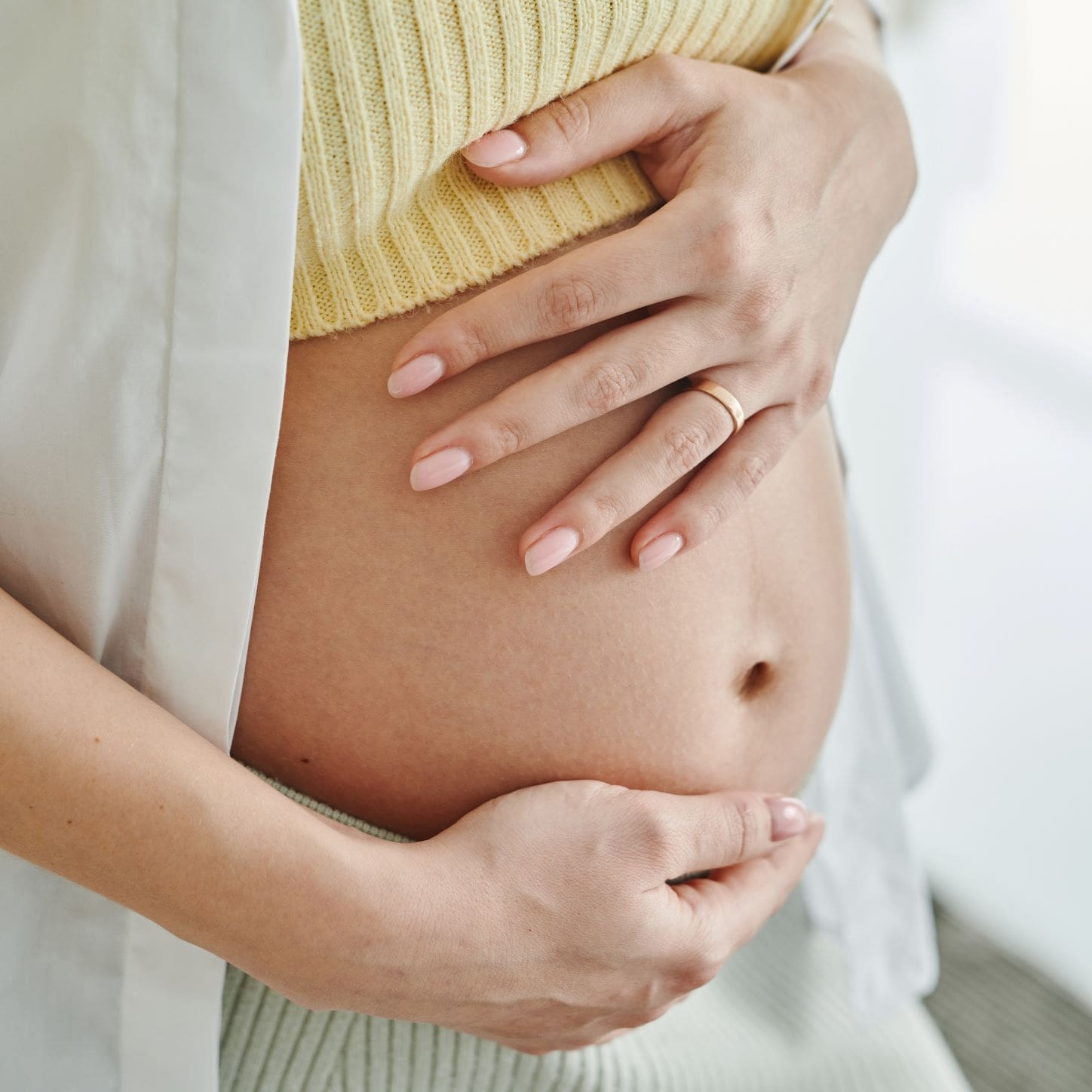 Woman holding pregnancy bump.