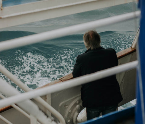 A person standing and looking out to see from the deck of a ferry