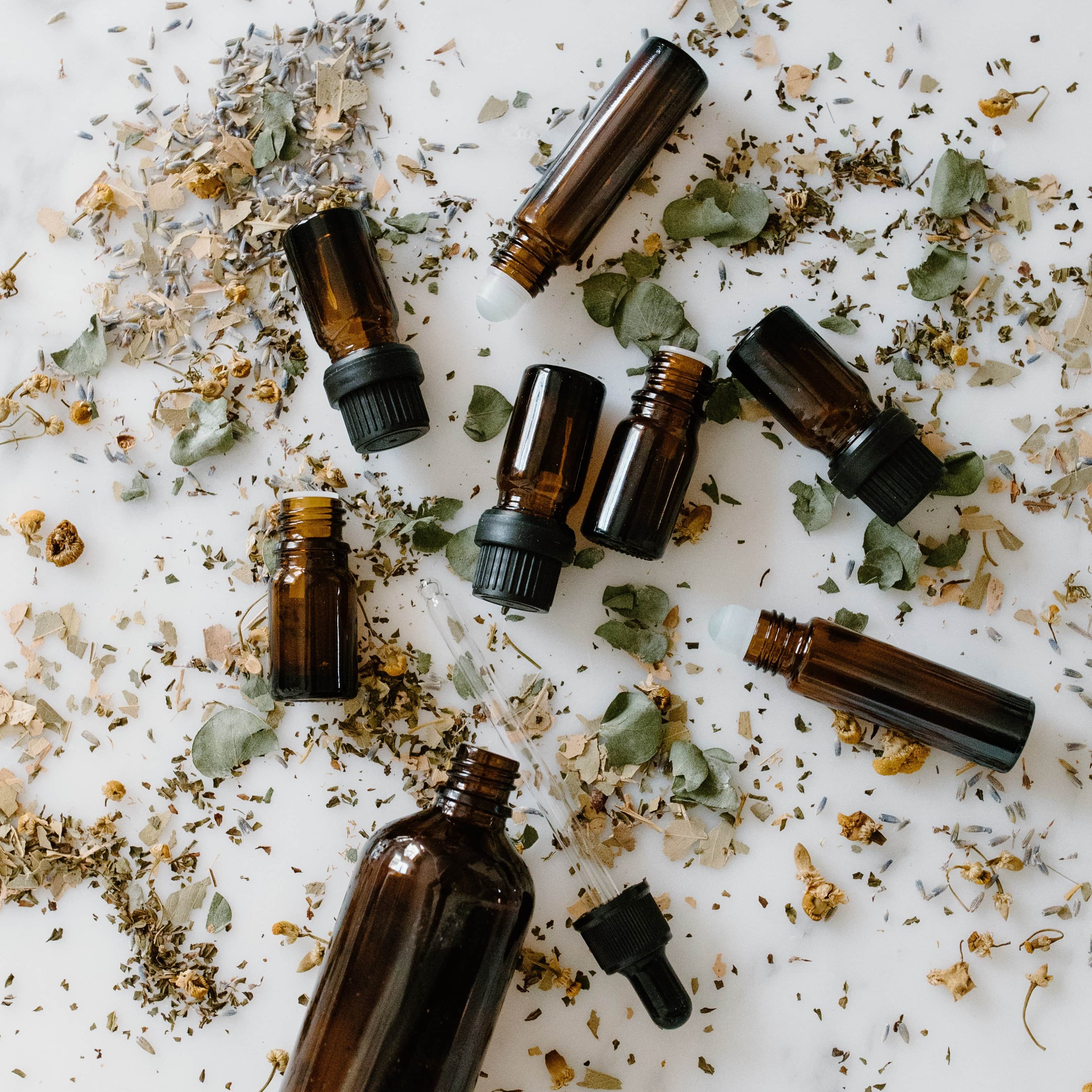 Assortment of essential oils with herbs.
