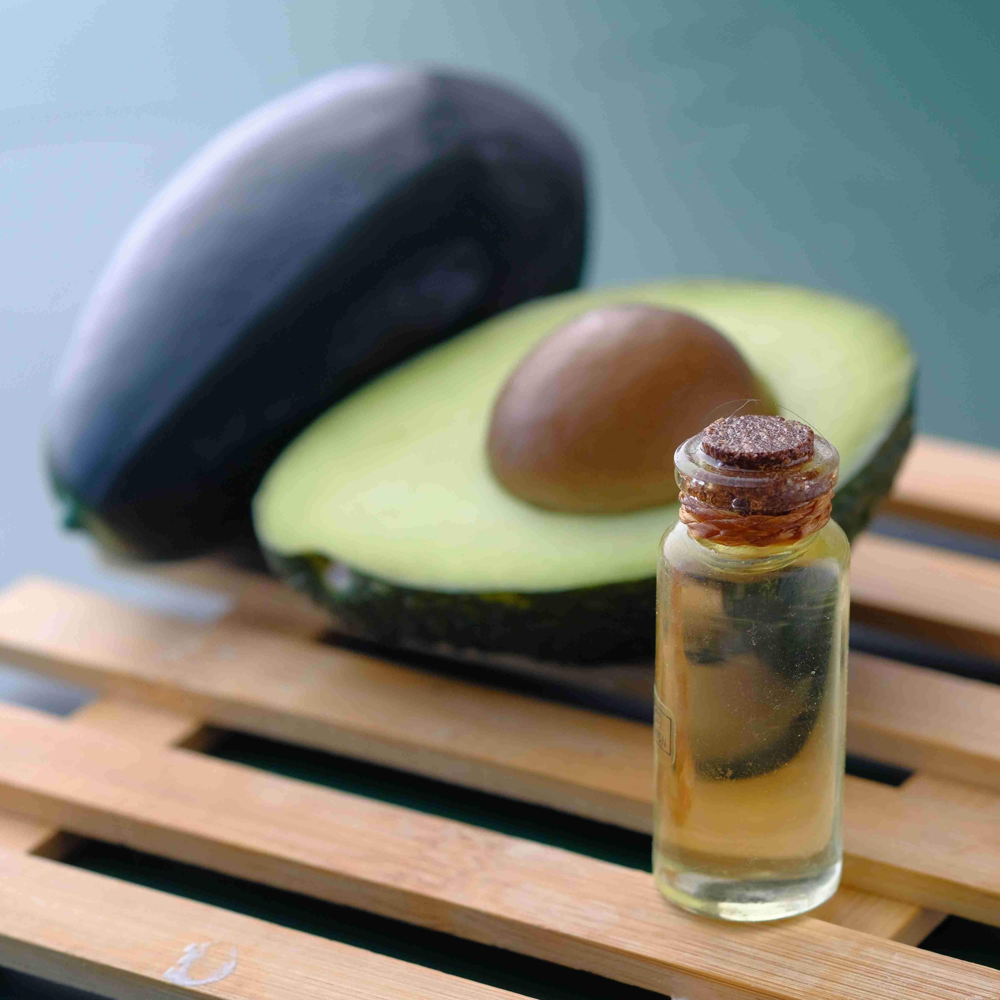 Chopped avocado next to a bottle of avocado oil.