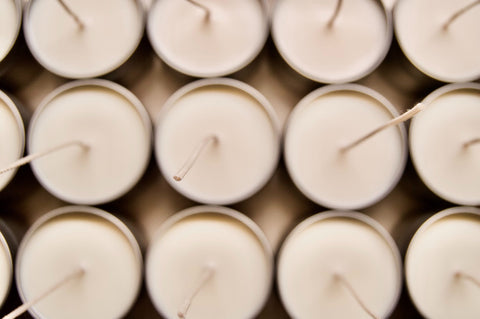 Above view of three rows of candles with very long wicks before cutting
