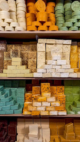 Four shelves packed with various shapes and colours of soap bars