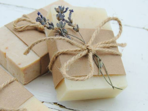 Two bars of soap with a cardboard wrap tied with string and lavender put in the string bow